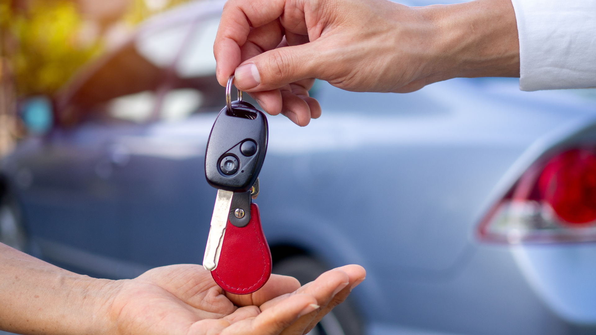 two hands exchanging a set of keys for a car loaner.